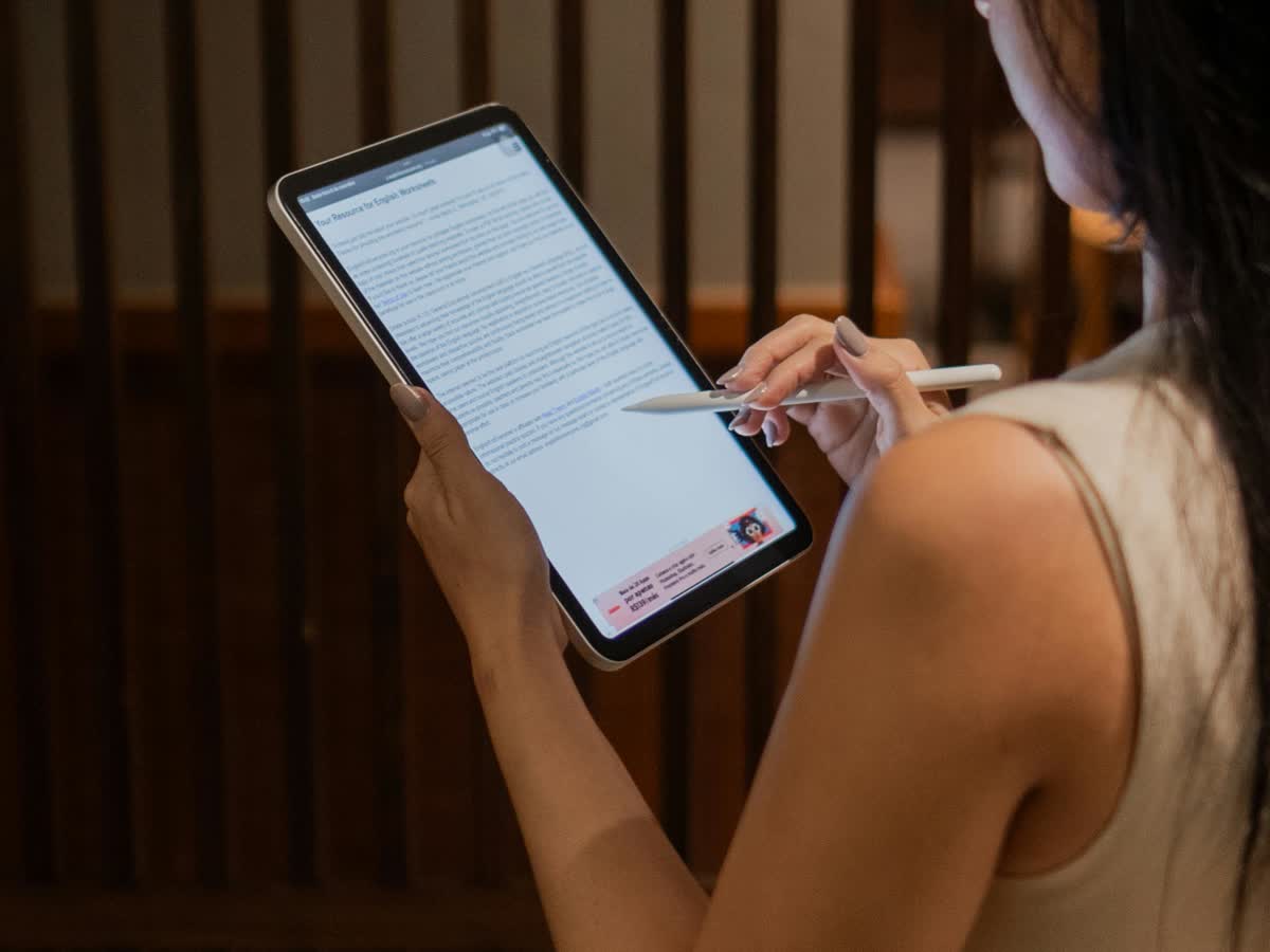 Professional reviewing documents on a tablet in a polished office setting.