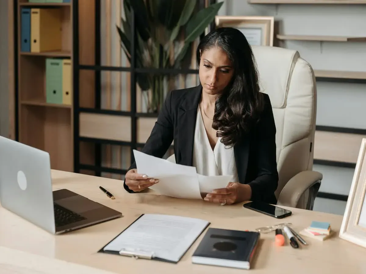 Professional reviewing paperwork at an organized office desk.
